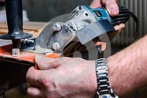 Construction worker cutting laminate using angle grinder with stand for 45 degree.