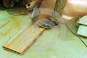 Construction worker cutting large ceramic bricks with electric cutter