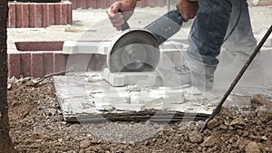 Construction worker cutting pavement stone with an angle grinder 4K with audio
