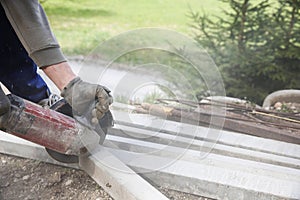 Construction worker cutting a reinforced concrete pillar