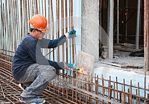 Construction worker cutting steel rods photo