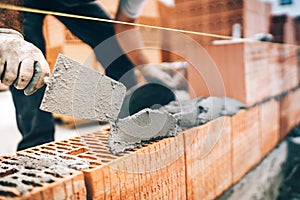 Construction worker details, protective gear and trowel with mortar building brick walls