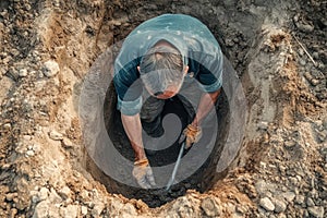 Construction worker digging hole top view