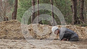 Construction Worker Digging Trench in a Forested Area During Daytime