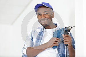 construction worker drilling hole in wall in new house