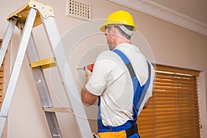 Construction worker drilling hole in wall