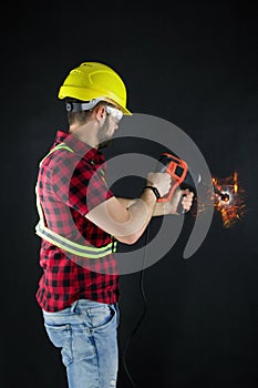 Construction Worker drills with a large demolition hammer  on black background.