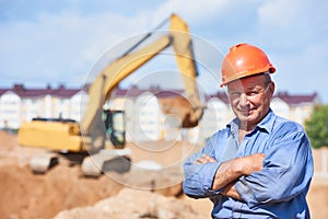 Construction worker driver in front of excavator loader