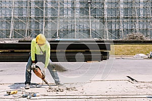 Construction worker electric drill Drilling concrete ground in