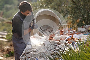 Construction worker emptying debris from carrycot