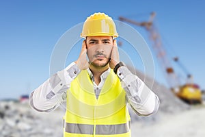 Construction worker or engineer covering his ears