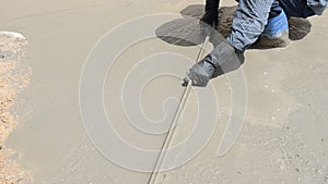 Construction worker finishes pouring concrete floor by troweling the cement