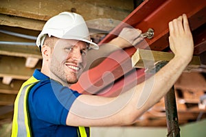 Construction Worker Fitting Steel Support Beam Into Renovated House Ceiling