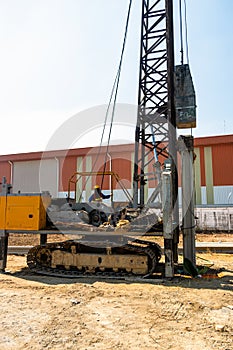 Construction worker Forced the crane to hammer the cement posts into the ground. Construction of industrial plants And the