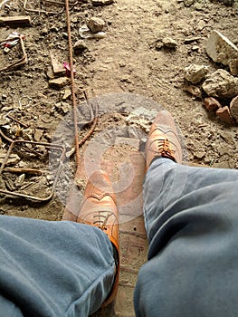Construction worker formal shoes at the construction site with blue trouser