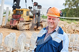 Construction worker in front of pile driver machine