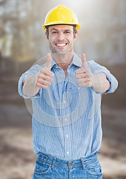 Construction Worker giving thumbs up in front of construction site