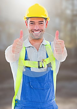 Construction Worker giving thumbs up in front of construction site