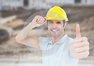 Construction Worker giving thumbs up in front of construction site