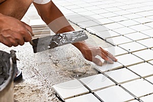 Construction site worker glued ceramic tile floor photo