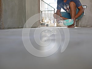 A construction worker grunting the ceramic tile floor - tiling work photo