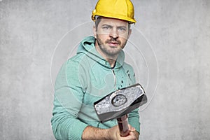 Construction worker with a hammer in hand, concept of construction and disassembly, renovation