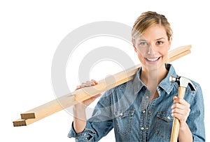 Construction Worker With Hammer And Wooden Planks On Shoulder