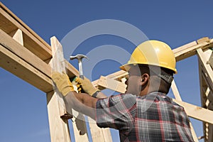 Construction Worker Hammering Nail On Timber Frame