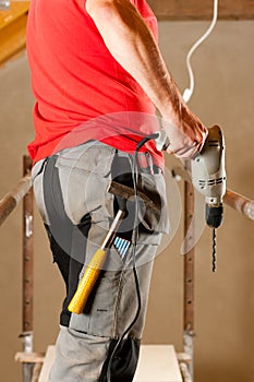 Construction worker with hand drill