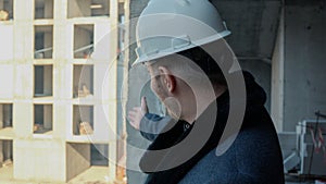 A construction worker in a hard hat looking up while standing inside a building