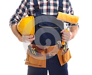 Construction worker with hard hat, paint roller and tool belt on white background