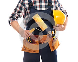 Construction worker with hard hat, paint roller and tool belt on white background