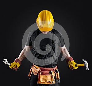 Construction worker in helmet with hammer and wrench
