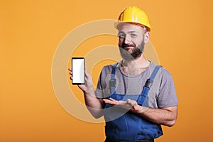 Construction worker holding cell phone with empty screen