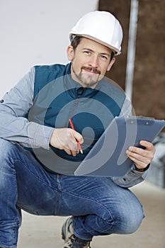 construction worker holding clipboard at home