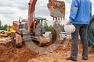 Construction worker holding and excavator