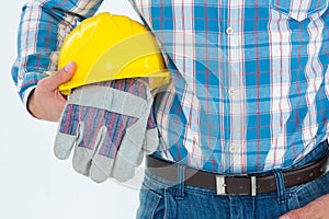 Construction worker holding hard hat and gloves