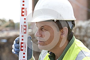 Construction Worker Holding Measure