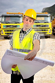 Construction worker holding project documents at construction site