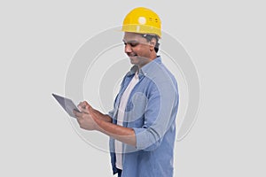 Construction Worker Holding tablet in Hands. Man Using Tablet. Architect Holding Tablet. Yellow Hard Helmet. Worker