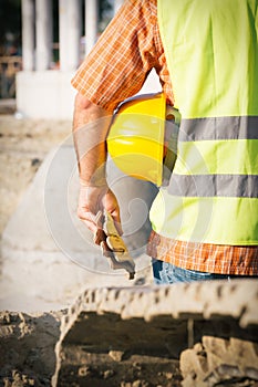 Construction worker holding yellow hardhat