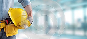 The construction worker holding a yellow safety helmet in a modern workspace. AI generated image