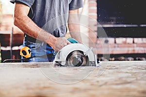 Construction worker, industrial carpenter using miter saw for cutting boards