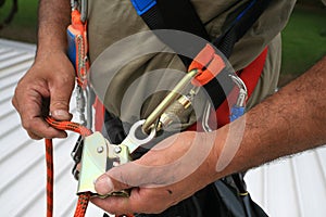 Construction worker inspection maintenance services on safety rope crap equipment device connected with locking Karabiner