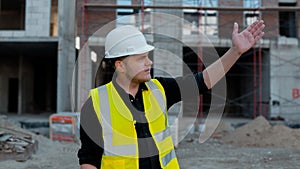 A construction worker inspects the wall of a building on a construction site.