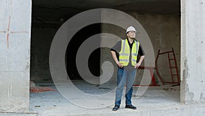 A construction worker inspects the wall of a building on a construction site.
