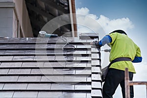 Construction worker install install new ceramic tile roof, Roofing tools, Electric drill used on new roofs on construction site