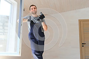 Construction worker installing new window in house