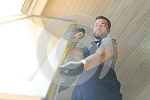 Construction worker installing new window in house