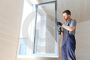 Construction worker installing new window in house